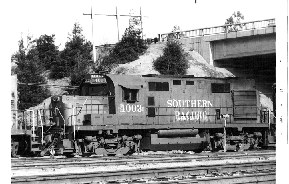 Black and white photo of Southern Pacific 4003 engine near a highway underpass. 